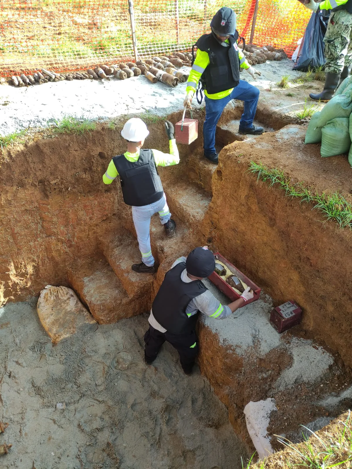 Especialista inspeccionando un artefacto recuperado en un área acordonada